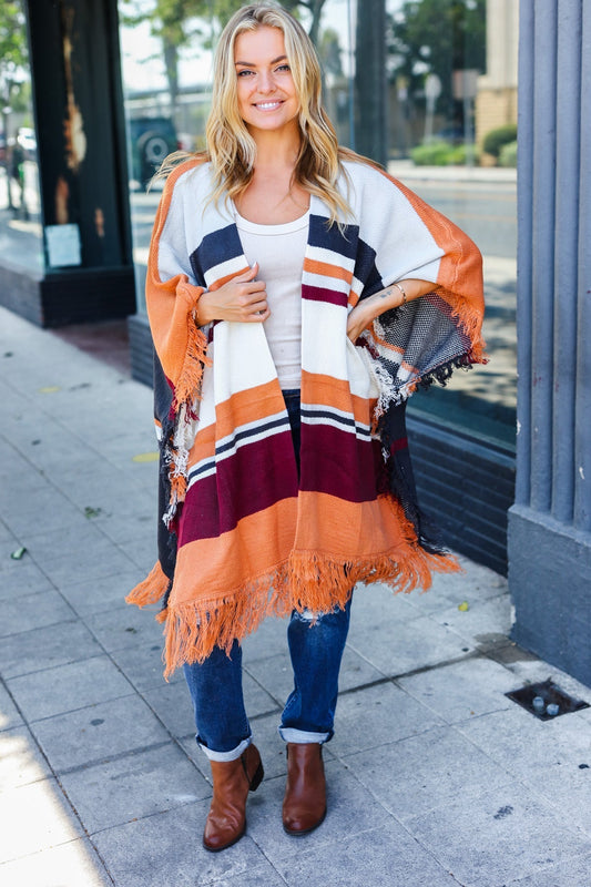 Zoe | Follow Me Rust colored open poncho with multi colored stripes and tassel fringes