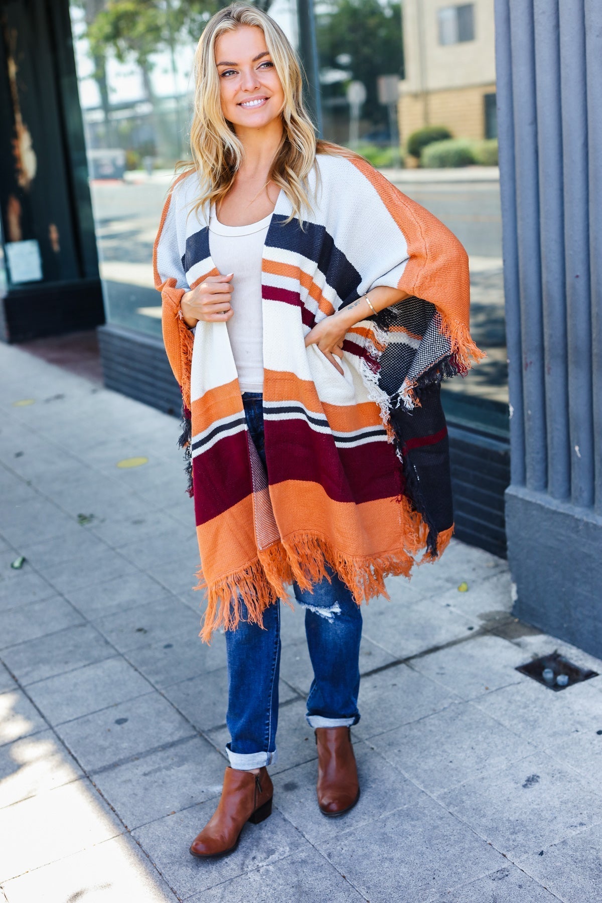 Zoe | Follow Me Rust colored open poncho with multi colored stripes and tassel fringes