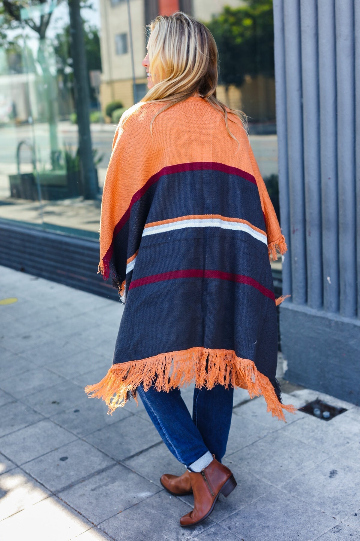 Zoe | Follow Me Rust colored open poncho with multi colored stripes and tassel fringes